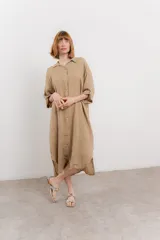 Vestido camisero midi color verde militar, de lino 100%, con silueta oversize, cuello camisero, mangas 3/4 con botón para ajustar y aberturas laterales.