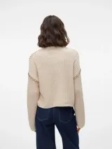 Sweater de punto color crema con cuello alto, mangas largas y hombros caídos.