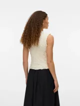 Top tejido color crema, sin mangas y con cuello redondo. Confeccionado en punto plano con mezcla de viscosa LENZING™ ECOVERO™ y nailon. Diseño de calce regular, textura suave y caída ligera.