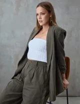 Blazer blanco de lino con cuello con solapa, bolsillos sastre y mangas fruncidas.
