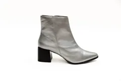 Bota de cuero negra, de caña corta y punta fina, con cierre lateral y taco geométrico de 6 cm.