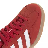 Championes Adidas Gazelle Indoor color rojo con las tres tiras laterales blancas y suela color caramelo.