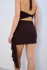 Minifalda marrón con drapeado lateral y detalle de hebilla dorada.