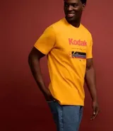 Remera amarilla de algodón con cuello redondo y mangas cortas. Estampado frontal con el logo de Kodak y un rollo de película.