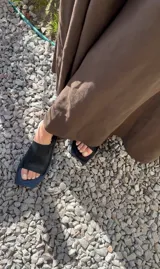 Sandalias planas negras de cuero con punta cuadrada y diseño minimalista.