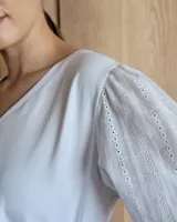 Blusa blanca de mangas 3/4 abullonadas con escote en V.