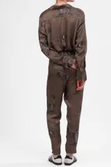 Pantalón de seda cupro color verde con estampado de leopardos alados, corte recto, bolsillos al frente y elástico en la cintura.