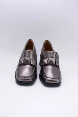 Mocasines de cuero color peltre con taco cuadrado y aplique geométrico al tono.