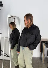 Campera marrón con cuello camisero, corte cuadrado, cierre frontal con botones y flecos en espalda y mangas.