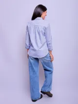 Camisa entallada de manga larga color rosa claro, con cuello clásico y cierre frontal con botones.