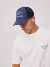 Gorra azul marino con visera, de lona de algodón y malla trasera. Estampado frontal con el logo de la marca Rusty.