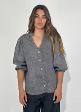 Camisa celeste de lino con mangas 3/4 abullonadas y cuello en V con volados.