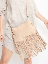 Bandolera de gamuza color beige con flecos largos en la parte inferior. Tiene correa larga regulable del mismo material.