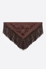 Pañuelo de seda o material similar, color marrón oscuro, de forma triangular y con largos flecos en los bordes. Presenta bordados florales tonales en el centro.