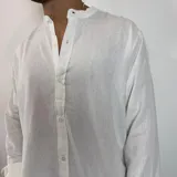 Camisa de lino blanca con cuello mao, manga larga y corte regular.