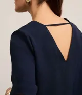 Blusa roja de crepé con escote en V, mangas cortas y corte holgado.