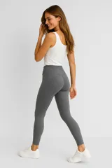 Calza deportiva gris de poliéster, tiro alto y corte ajustado.