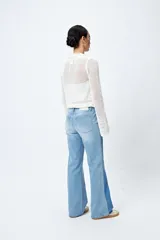 Pantalón de jean negro de corte recto, tiro medio y calce relajado. Presenta un recorte lateral en tono contrastante.
