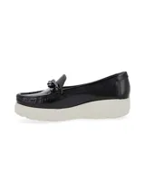 Mocasín de cuero charol negro con plataforma blanca y detalle de hebilla metálica plateada en el empeine.