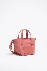 Bolso shopper mini Bimba y Lola color coral, confeccionado en nylon de estructura blanda con doble asa de mano y asa de tejido, piezas de piel, logo grabado y cierre de cremallera.