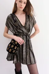 Vestido corto con escote cruzado en V y manga corta, confeccionado en tul con tejido de rayas doradas y negras. Presenta un lazo para ajustar la cintura y un viso interior con breteles regulables.