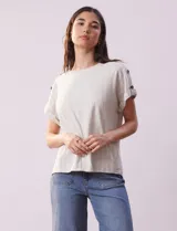 Blusa de lino color blanco con rayas verticales, de la marca Cable & Gauge. Tiene hombros con aplique de botones.