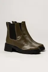 Bota Chelsea de cuero color verde militar, con elástico lateral negro, suela track y taco cuadrado bajo.