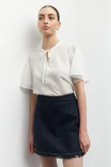 Blusa celeste a rayas verticales con cuello mao, mangas cortas y lazo en el frente.