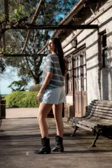 Remera de punto gris con rayas horizontales celestes, corte recto y mangas cortas.