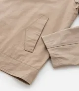 Campera masculina color marrón confeccionada en sarga, con cuello inglés, cierre de cremallera frontal, manga larga y bolsillos con detalles.