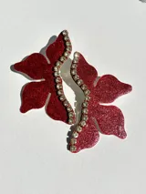 Aros colgantes con forma de flor roja con glitter, detalle de strass y gancho de acero quirúrgico.
