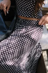 Pollera larga de viscosa con estampado de lunares blancos sobre fondo negro.