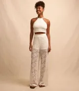 Blusa cropped blanca de encaje con cuello halter, breteles finos con lazo en la espalda y lastex en la espalda.