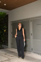 Conjunto de chaleco y pantalón negro con finas rayas verticales blancas. El chaleco es entallado, con escote en V y cierre frontal con botones. El pantalón es de corte palazzo.