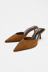 Zapato tipo mule destalonado color marrón, de ante, con escote redondo, punta fina y tacón medio fino.