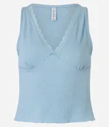 Blusa musculosa celeste confeccionada en anarruga, con escote en V y detalle de encaje.