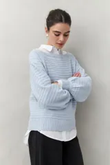Sweater negro tramado de silueta relajada, con combinación de texturas en el tejido y mangas abullonadas con puños elastizados.