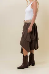 Pollera corta asimétrica de gamuza color marrón, con volados superpuestos y cintura elastizada. Incluye short interno.