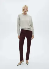 Pantalón de vestir color borgoña con finas rayas verticales, de tiro medio, corte recto y bolsillos traseros de ribete. Cierre frontal oculto con botón, gancho y cremallera.