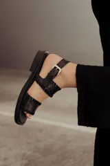 Sandalias de cuero marrón con tiras tejidas a mano y costuras a la vista.