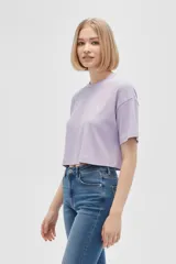 Remera cropped lila de algodón con cuello redondo y estampado de una concha marina en el pecho.