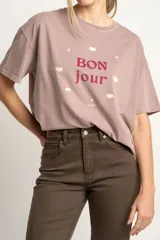 Remera color lila con estampa frontal de la frase 'Bon jour' con estrellas y labios.