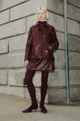 Chaqueta biker de cuero sintético color bordó, con cierre asimétrico y cuello con solapas.