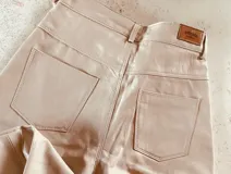 Pantalón de cuero ovino italiano color nude, corte mom fit con tiro semi alto y tajos inferiores.