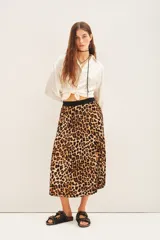 Falda midi plisada con estampado animal print de leopardo en tonos marrones y negros, con cintura elástica negra.