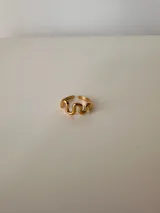 Anillo dorado con forma ondulada, ajustable entre 16mm y 19mm, de acero quirúrgico hipoalergénico.
