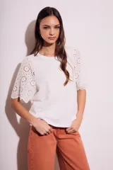 Remera blanca de algodón peinado con calce oversize y mangas cortas con detalle de calados.