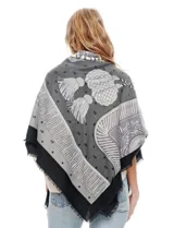 Pashmina grande con estampado tipo patchwork en tonos de gris, blanco y negro. Presenta un borde liso negro y flecos en los extremos.