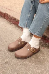 Zueco marrón de cuero con hebilla dorada ajustable y plantilla anatómica de corcho.