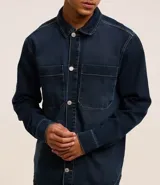 Camisa masculina oversized confeccionada en jeans azul oscuro, con cuello inglés, manga larga, puño ajustado, abotonado delantero y dos bolsillos cargo en el pecho.